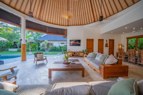 ein Wohnzimmer mit Sofa und Tisch in der Unterkunft Villa Lea - 5BR luxury oasis in Seminyak with pool in Kerobokan