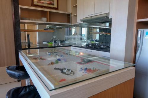 バンドンにあるSpacious and Combine 3BR at The Edge Bandung Apartment By Travelioのおもちゃが入ったキッチンのガラスカウンター