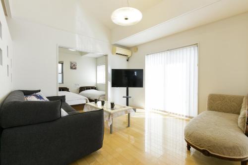 a living room with a couch and a tv at -華 HANA- Vacation Rental in Nagoya