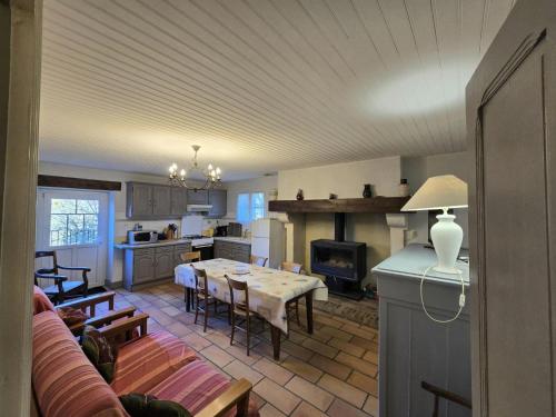 une cuisine et un salon avec une table et une salle à manger dans l'établissement Maison de Charme à la Ferme avec Jardin, Cheminée et Wifi, près de Périgueux - FR-1-616-40, à Mensignac