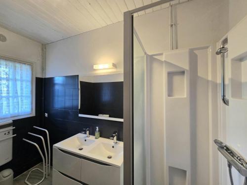 une salle de bain avec un lavabo et une télévision au mur dans l'établissement Maison de Charme à la Ferme avec Jardin, Cheminée et Wifi, près de Périgueux - FR-1-616-40, à Mensignac