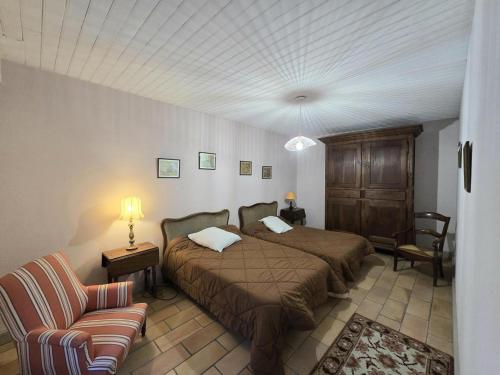 une chambre avec un lit, un canapé et une chaise dans l'établissement Maison de Charme à la Ferme avec Jardin, Cheminée et Wifi, près de Périgueux - FR-1-616-40, à Mensignac