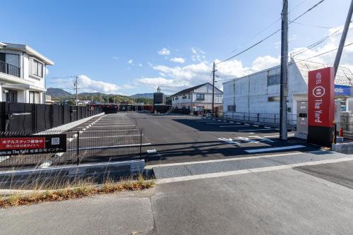 an empty parking lot next to a building at HOTEL R9 The Yard Iwakunikugainter in Iwakuni