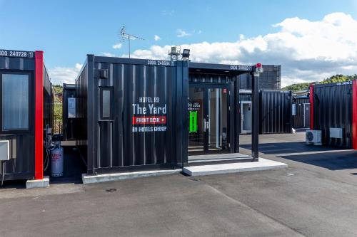 a group of shipping containers in a parking lot at HOTEL R9 The Yard Iwakunikugainter in Iwakuni