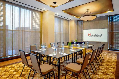 a conference room with a large table and chairs at Swiss-Belhotel Airport Yogyakarta in Yogyakarta