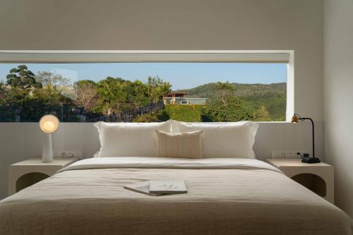 a bedroom with a bed with a large window at Miyue Shenzhen Blue and White Holy Island Cliff Pool Hotel in Shenzhen