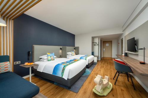 a hotel room with two beds and a desk at Holiday Inn Express Jiangmen Jianghai by IHG in Jiangmen