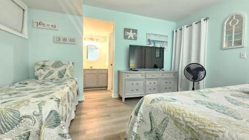 a bedroom with two beds and a flat screen tv at 2BR/2BA Condo at Arcadian Dunes Building 10-238 in Myrtle Beach