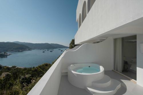 a bathroom with a toilet and a view of the water at Miyue Shenzhen Blue and White Holy Island Cliff Pool Hotel in Shenzhen