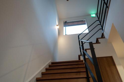 a staircase in a house with a window at Takinoyu House in Nozawa Onsen