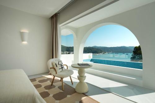 a bedroom with a large window with a view of the water at Miyue Shenzhen Blue and White Holy Island Cliff Pool Hotel in Shenzhen