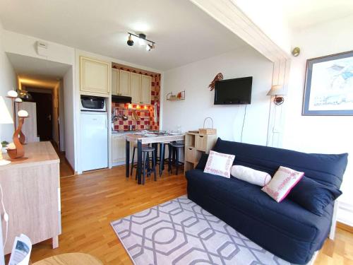 un salon avec un canapé bleu et une cuisine dans l'établissement Studio 4 personnes avec balcon à Saint-Lary-Soulan - FR-1-457-361, à Saint-Lary-Soulan