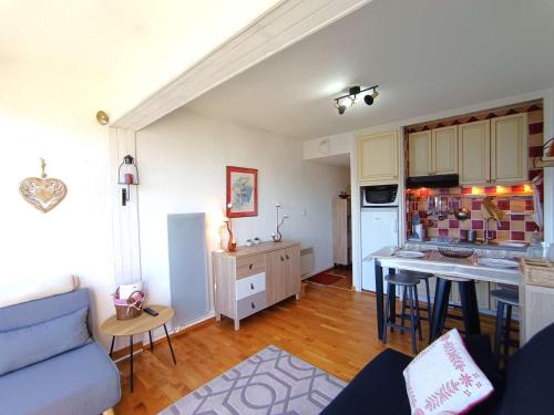 un salon avec un canapé bleu et une cuisine dans l'établissement Studio 4 personnes avec balcon à Saint-Lary-Soulan - FR-1-457-361, à Saint-Lary-Soulan