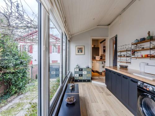 a kitchen with a counter and a large window at Maison arcachonnaise 3 ch., jardin, proche plage et commerces, WIFI - FR-1-433-129 in Arcachon