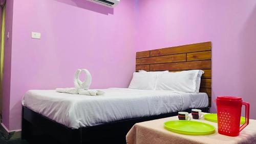 a bedroom with a bed with a pink wall at skywayrooms near Indira Gandhi signal in Puducherry