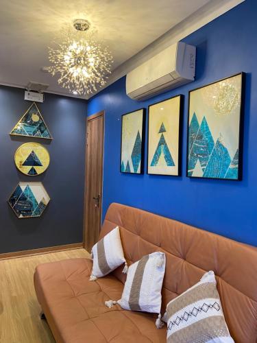 Buôn Dhă PrŏngにあるKakul A'Houseの青い壁に囲まれたリビングルーム(茶色のソファ付)