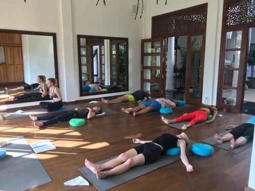 a group of people doing yoga in a room at Niyagama House in Galle