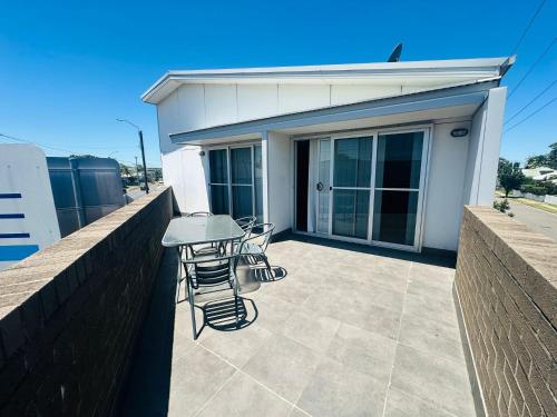 a patio with a table and chairs in front of a building at Aspire Newcastle in Newcastle