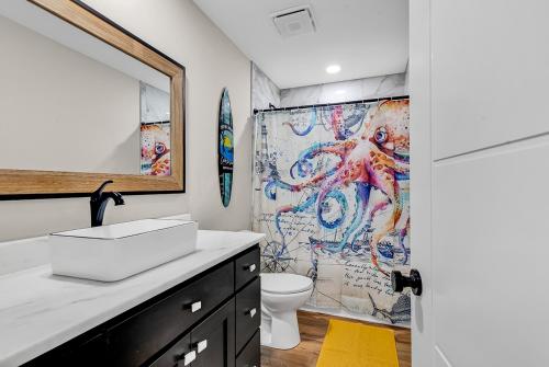 a bathroom with a sink and a shower curtain at Ocean Lakes getaway 6bd with arcade game table in Myrtle Beach