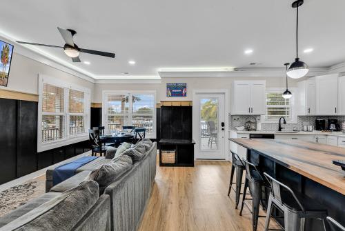 a kitchen and living room with a couch and a table at Ocean Lakes getaway 6bd with arcade game table in Myrtle Beach