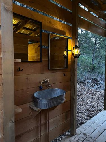 a bathroom with a blue sink on a wooden wall at Butterfly Cottage - open air eco villa in Oliver