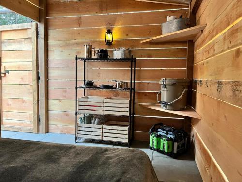 ein Raum mit Holzwänden und ein Raum mit Regalen in der Unterkunft Butterfly Cottage - Glamping in Oliver