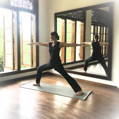 a woman doing a yoga pose in front of a mirror at Niyagama House in Galle