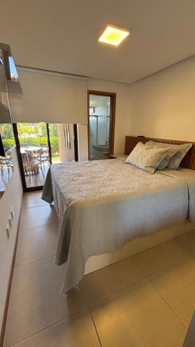 a bedroom with a large bed and a balcony at Loft de praia - Itacimirim BAHIA in Itacimirim
