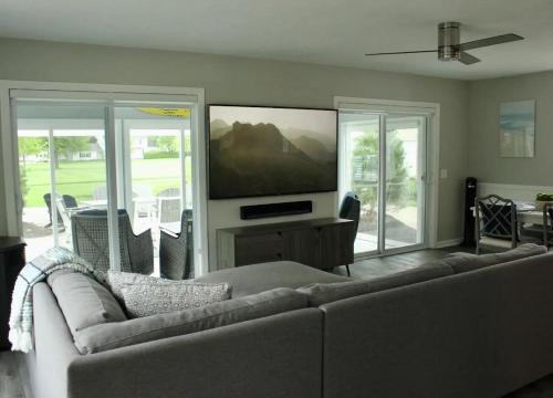 a living room with a couch and a flat screen tv at At the Beach - Old Homestead Beach House in Huron