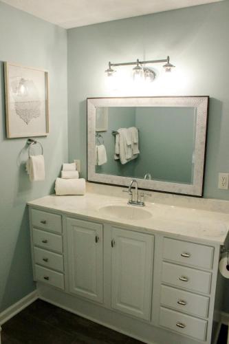 a bathroom with a sink and a mirror at At the Beach - Old Homestead Beach House in Huron