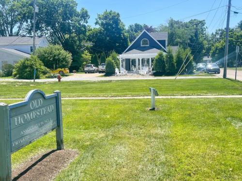 a sign in the grass in front of a house at At the Beach - Old Homestead Beach House in Huron