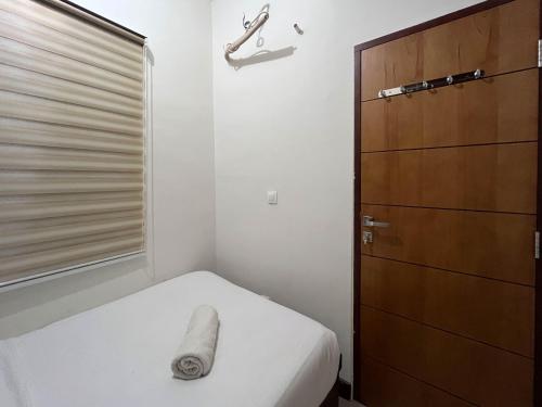 PampangにあるWarm and Cozy 2BR Vida View Makassar Apartment By Travelioのベッドとドレッサーのある小さな寝室