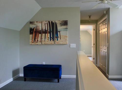 a room with a blue ottoman and surfboards on the wall at At the Beach - Old Homestead Beach House in Huron