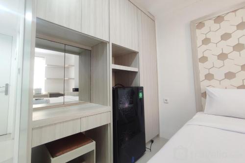 a small bedroom with a bed and a mirror at Nice Cozy Studio at Paltrow City Apartment By Travelio in Semarang