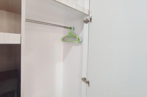 a door with a hanger on a white wall at Nice Cozy Studio at Paltrow City Apartment By Travelio in Semarang