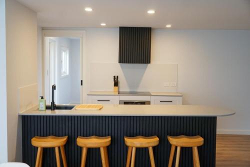 NewsteadにあるCarinya Charming Newstead homeのキッチン(カウンター、4つのバースツール付)