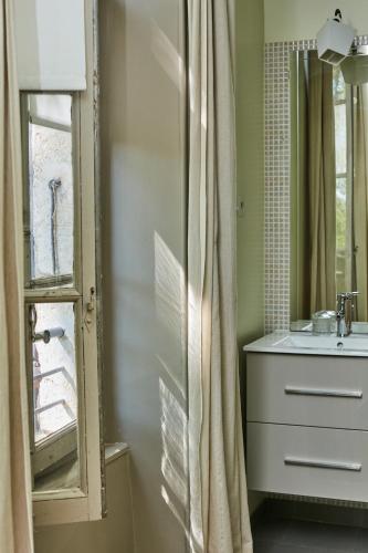 une salle de bain avec un lavabo et un miroir dans l'établissement Fontclaire en Provence, à Uchaux