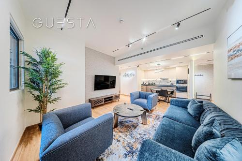 a living room with two blue couches and a table at Jumeirah Beach Residence - Rimal 6, Dubai Marina in Dubai