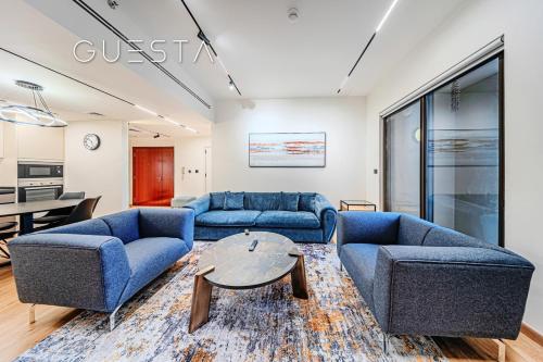 a living room with blue couches and a table at Jumeirah Beach Residence - Rimal 6, Dubai Marina in Dubai
