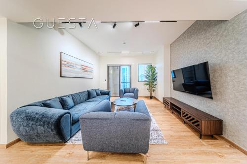 a living room with a blue couch and a tv at Jumeirah Beach Residence - Rimal 6, Dubai Marina in Dubai