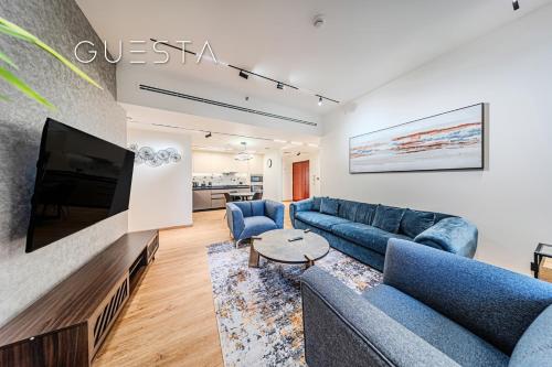 a living room with blue couches and a flat screen tv at Jumeirah Beach Residence - Rimal 6, Dubai Marina in Dubai