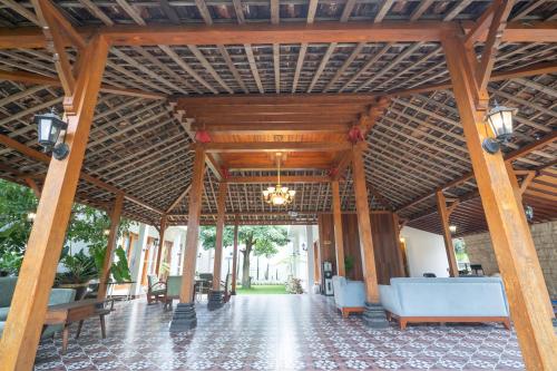 a large wooden pavilion with blue chairs and tables at Kinkeo Borobudur in Magelang