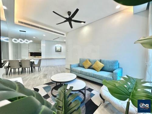 a living room with a blue couch and tables at PineTree Puteri Harbour by RR JBcity in Nusajaya