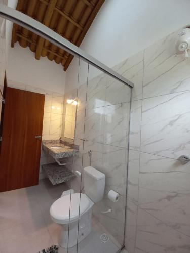a bathroom with a toilet and a glass shower at Casa Lua in Prado