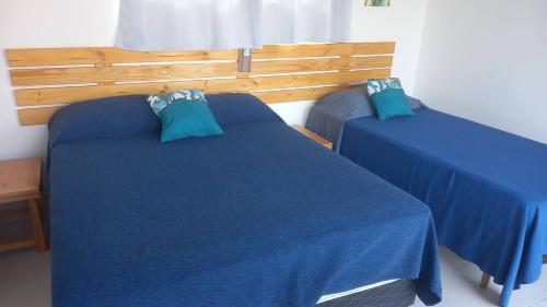 two beds in a room with blue sheets at Casa Lua in Prado