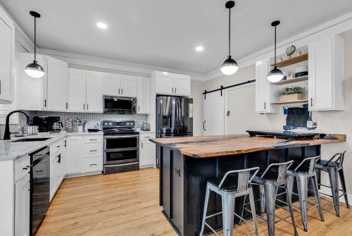 a kitchen with white cabinets and a large island with bar stools at Ocean Lakes Walk to beach! Waterpark! Arcade! Dogs Welcome! in Myrtle Beach