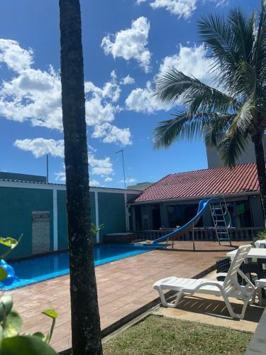a house with a pool and a palm tree at Casa de Praia Itanhaém in Itanhaém