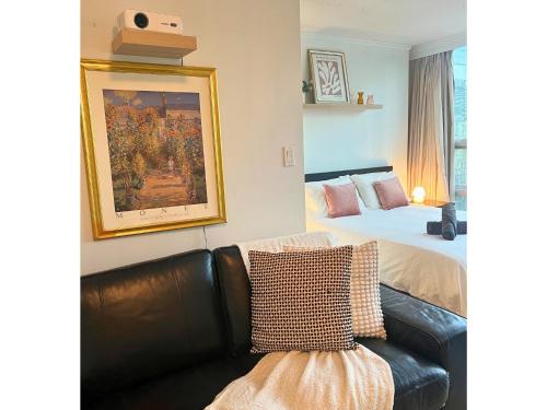 a bedroom with a bed and a couch and a painting at City Retreat With Views in the Heart of Downtown in Vancouver