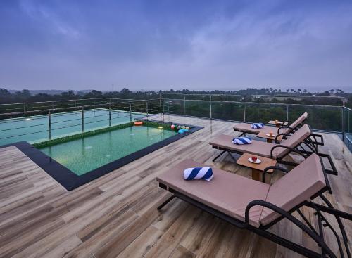 a balcony with a swimming pool on top of a building at Grand Continent Mahabalipuram A Sarovar Premiere Affiliate Hotel in Mahabalipuram