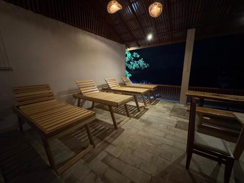 a row of wooden benches sitting on a patio at mc villa bunaken in Bunaken